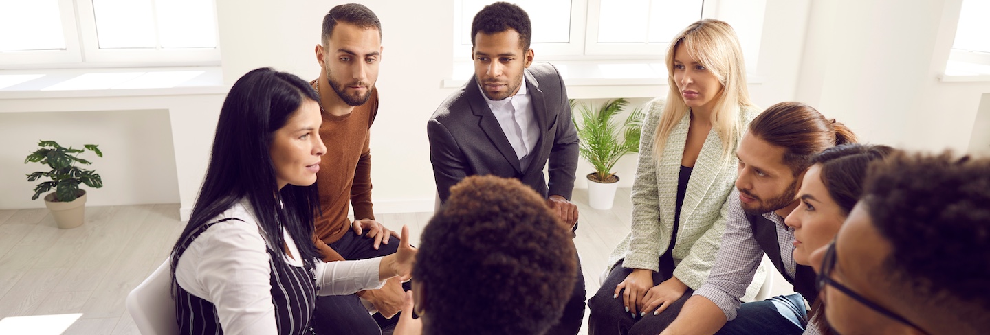 A group therapy session for individuals recovering from drug addiction while considering the cost differences between treatment programs.