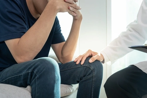 A compassionate doctor talks with a young man about Suboxone treatment for Opioid addiction