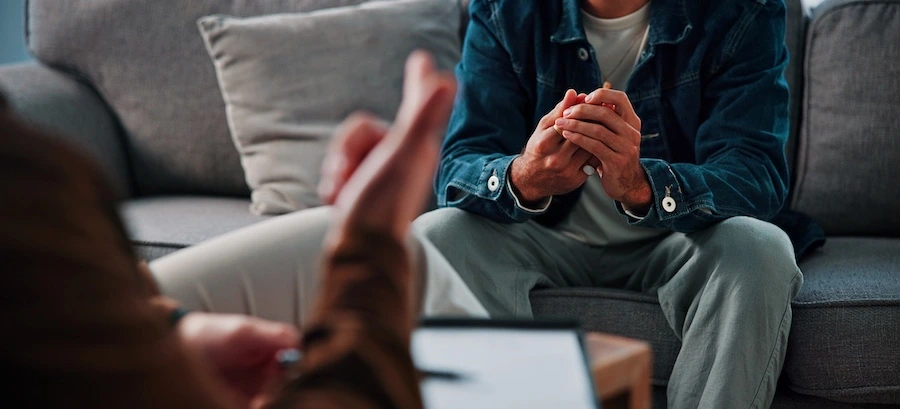 A therapist is speaking with a client at an alcohol rehab center.