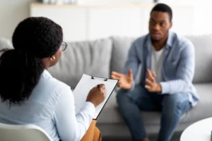 Photo of a healthcare practitioner leading a therapy session that addresses co-occurring PTSD and alcohol abuse, underlining the significance of integrated exposure-based therapy for recovery.
