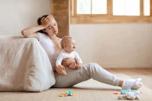 New mother holding her baby, illustrating postpartum depression and addiction risk factors while experiencing postpartum depression symptoms.